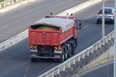 Kırmızı çöp kamyonu otobanda kum taşıyor. Havadan bakıldığında görülebiliyor.