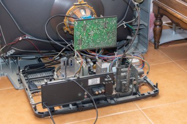 Parçalanmış bir crt televizyon setinin iç görünümü karmaşık elektronik ve kabloları ortaya çıkarıyor