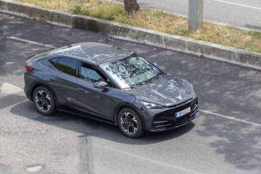 Modern gri elektrikli araba yolda gidiyor, hava manzaralı.