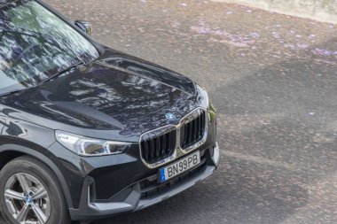 Tarz sahibi siyah bmw x1 asfalt bir yolda ilerliyor, parlak tasarımı ve dinamik performansını sergiliyor