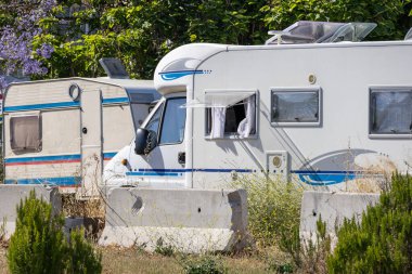 Beyaz karavan ve karavan beton bariyerlerin arkasına park etmişler. Bu da geçici ya da yasak bir kamp alanı olduğunu gösteriyor.
