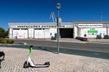 Cima Otomotiv Denetleme Merkezi Lisbon, Portekiz 'in önündeki kaldırıma park etmiş beyaz elektrikli scooter.