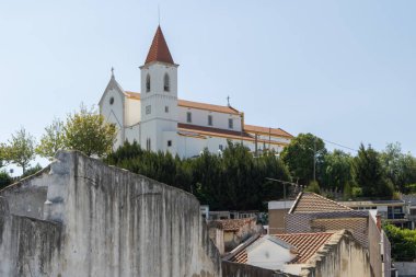 Vaftizci Aziz John Kilisesi Portekiz 'deki Alhandra' nın siluetine hükmediyor. Beyaz cephesi ve turuncu kiremitli çatısı var.
