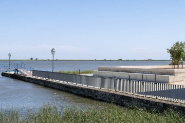 Bir rıhtım, sakin sular ve Alhandra, Portekiz 'de berrak mavi bir gökyüzü içeren sakin bir manzara.