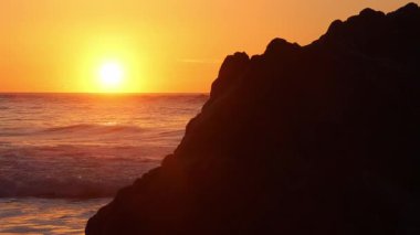 Adraga sahilinin kayalık sahillerini aydınlatan altın gün batımı, sintra, Portekiz