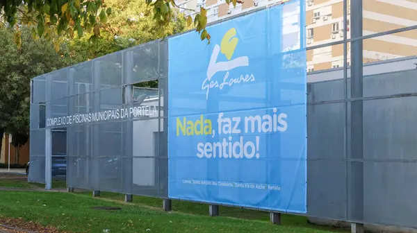Üzerinde ges loures logosu ve sloganı olmayan büyük mavi bir pankart, faz mais sentido. Portela belediyesinin havuz kompleksinin dışındaki bir çitte görüntülendi