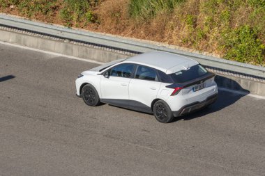 Modern beyaz araba güneşli bir günde otoyolda gidiyor.