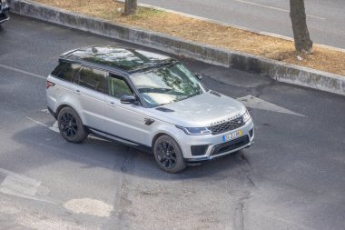 Hava perspektifinden Lizbon 'da şehir yolunda gümüş SUV geziniyor.