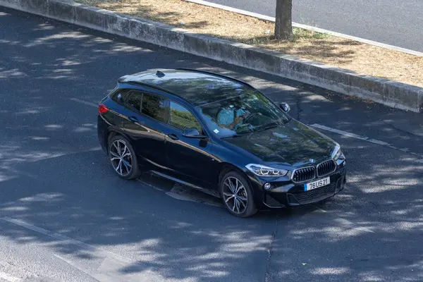 Kentsel çevrede asfalt yolda giden modern siyah bmw x2 araba