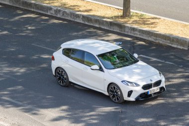 Modern beyaz BMW serisi 2 aktif turnuva. Yaz güneşinin altında kentsel bir yolda sürüyorlar.