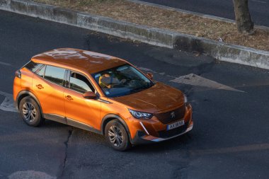 Modern turuncu peugeot 2008 SUV asfalt yolda sürüyor