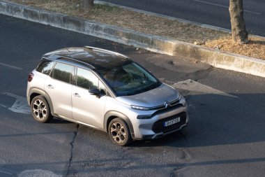 Gümüş Citroen C3 asfalt yolda ilerliyor.