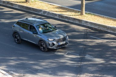 Modern gri peugeot 2008 şehirde asfalt yolda gidiyor