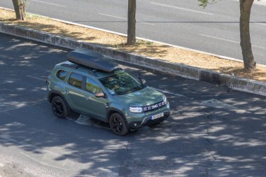 Güneşli yaz gününde asfalt yolda, tavan rafı olan modern bir araba.