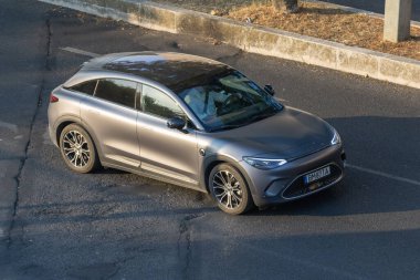 Modern akıllı 1 elektrikli araç asfalt yolda gidiyor.