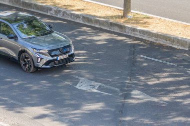 Modern Renault austral ikonik ruhlu alp asfalt yolda gidiyor.