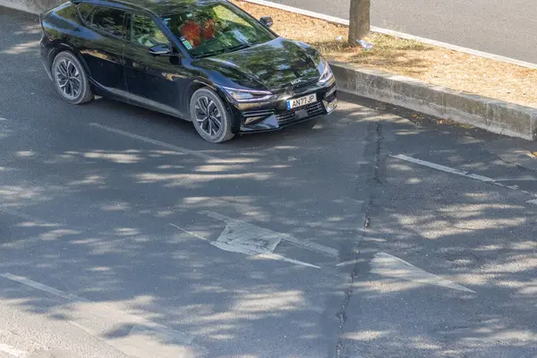 Çağdaş elektrikli araba şehir yolunda hasarlı trafik levhası, sürüş, ulaşım ve karayolu altyapısını temsil ediyor