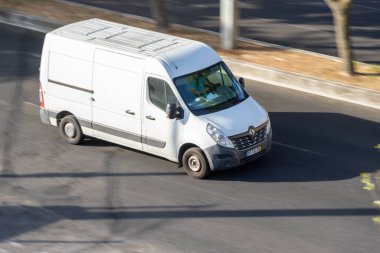 Beyaz minibüs gündüz otoyolda hızla gidiyor.