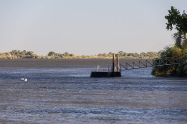 Nehir kıyısına bağlı yüzen duba suya erişimi sağlıyor.