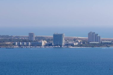 Distant view of troia peninsula hotels, marina, and boats on the atlantic ocean in setubal, portugal