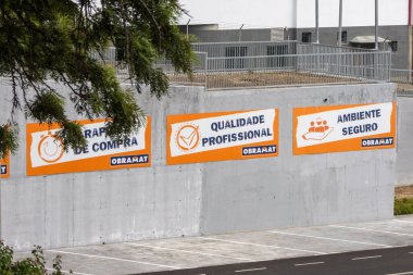 Obramat, a building materials store, emphasizes professional quality and a safe environment through large banners on its premises