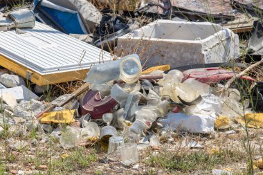 Garbage consisting of plastic and glass polluting nature, representing environmental risk and the need for recycling