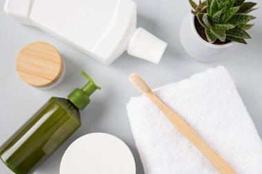 Natural cosmetics, aloe flower and bath accessories of personal hygiene and eco-materials are on a gray background. View from the top point.