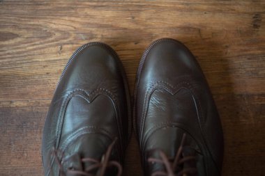  Erkeklerin kahverengi çizmeleri, tahta bir arka planda kör iplikler. Yukarıdan görüntüle.