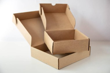 Two open empty cardboard boxes are on a bright background. clipart