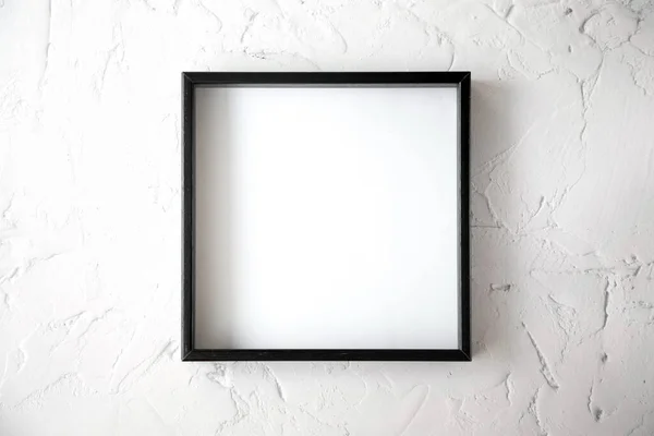 The black square frame is on a textured light background in the center of the image. View from the top.