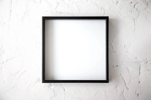 The black square frame is on a textured light background in the center of the image. View from the top.