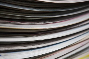 Kenarlarında boya olan beyaz çarşaflar bir matbaada istiflenmiş. Kağıt yapraklarının soyut bir arkaplanı.