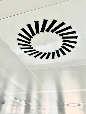 Dairesel havalandırma ofis binasının beyaz tavanında bulunuyor. Dikey fotoğraf.