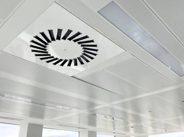 Dairesel havalandırma ofis binasının beyaz tavanında..