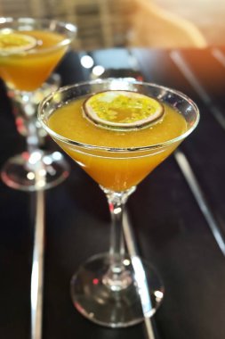 Sarı alkollü martini bardağı ve bir parça marakuja barda masanın üzerinde. Porno yıldızı martinili bir bardağın yakın çekimi..