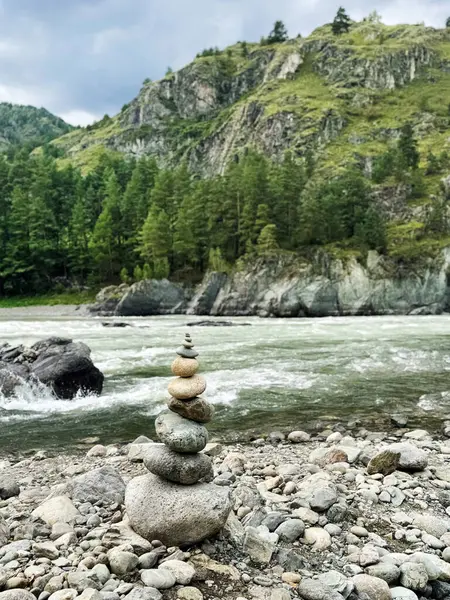 Yuvarlak taşlar, akan bir nehrin ve engebeli dağların zeminine karşı birbirinin üstünde dengelenmiş ve doğal denge kavramını somutlaştırmıştır. Altai, Rusya