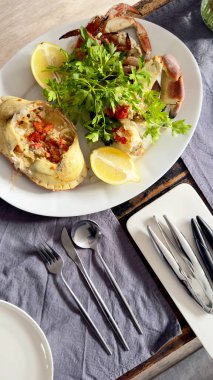 Servis masasında limonlu ve otlu hazır yengeç tabağı var..