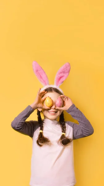 Lustiges Glückliches Mädchen Mit Osterhasenohren Und Bunten Ostereiern Auf Gelbem — Stockfoto