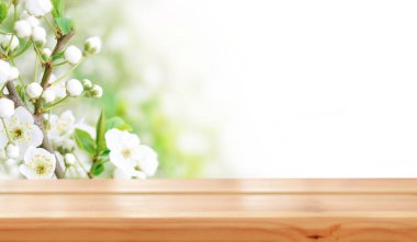 Baharda kiraz çiçeklerinin arka planında boş ahşap masa. Ürün montajı için hazır. Modelleme. Boşluğu kopyala.