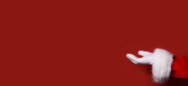 Noel Baba eli kırmızı bir arka planda mesajınızı, ürününüzü ve reklamınızı sunar. Boşluğu kopyala.