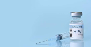 Mavi arka planda şırıngası olan bir şişede HIV aşısı. HIV hastalıklarına karşı aşı için deneysel HIV aşısı şişesi. Boşluğu kopyala