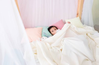 Tatlı çocuk süt şişesiyle yatağa uzan.