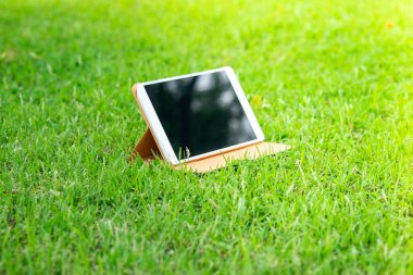 Yeşil çimlerde dijital tablet