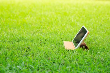 Yeşil çimlerde dijital tablet