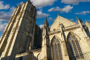 View of the cathedral of Le Mans in France illuminated by the sun and with the blue sky in the background with white clouds.