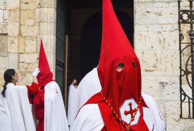 Holy Week in Palencia, Spain. Penitents with red hoods preparing for a procession in the city street.