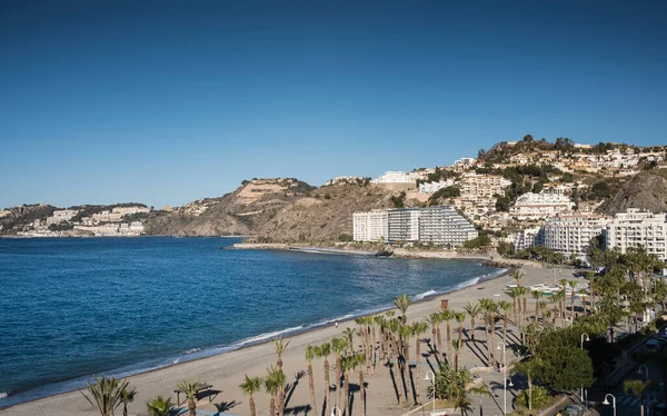 近代的な観光ビルやスペインのグラナダの澄んだ青い海とAlmunecar Beachと海岸の町の風景 ロイヤリティフリーのストック写真
