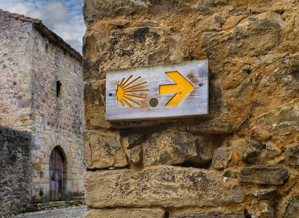 Cantabrian şehri Santillana del Mar 'da Camino de Santiago' nun simgesi olan taş bir duvardaki tahta tahta tahta..