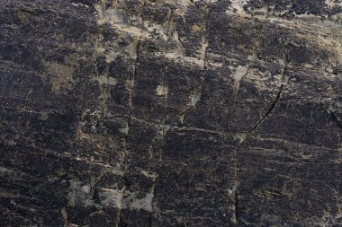 Sahilde bir sürü deseni ve koyu mavimsi tonları ve açık benekleri olan bir kaya. Arkaplan ve şablon kavramı.