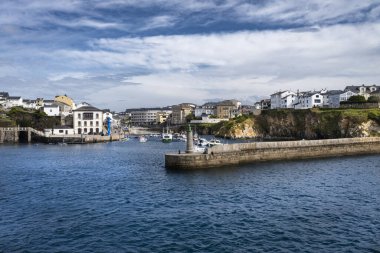 Mavi gökyüzü ve beyaz bulutlarla Asturian köyü Tapia de Casariego 'nun girişinin görüntüsü.